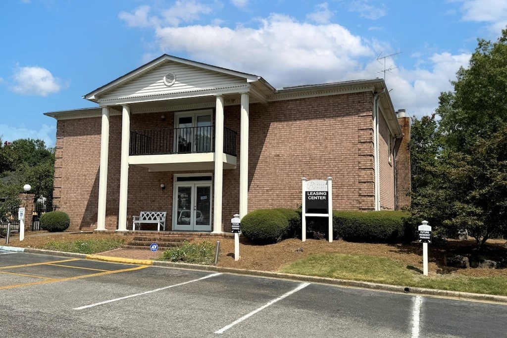 a brick building with a sign in front of a parking lot a brick building with a sign in front of a parking lot at Ascot Place Apartments, Birmingham